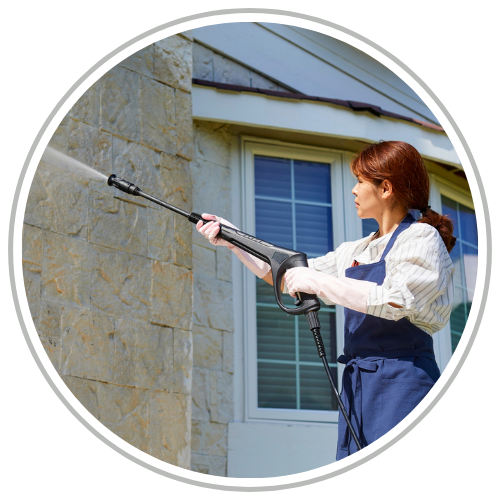 woman power washing the outside of a home. woman power washing the outside of a home.